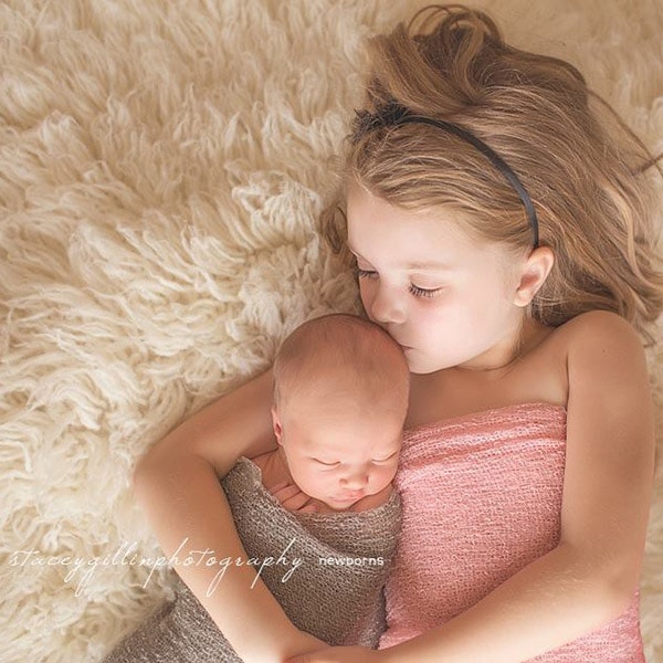 Jamie and Josh's two children cuddle on a blanket